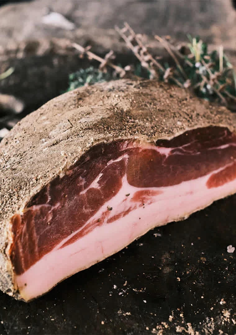 Prosciutto_di_maiale_nero_disossato_artigianale_stagionato_oltre_18_mesi_taglio_di_carne_con_grasso_
